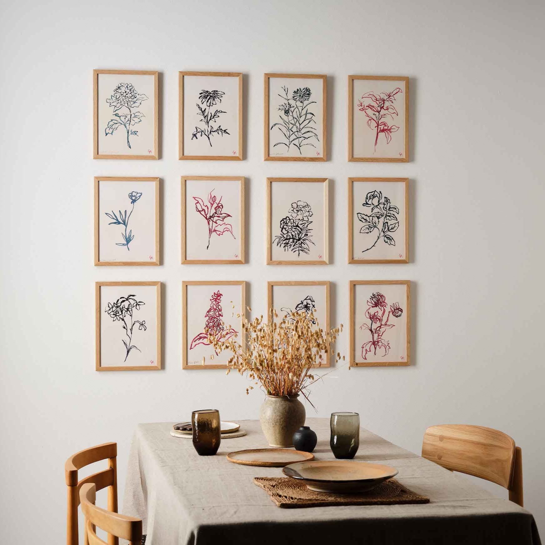 Atelier Auge Gallery wall setup featuring framed hand-drawn botanical illustrations of various flowers in a minimalist and contemporary style.