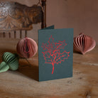 Holly Christmas card with red foiled line drawing on green cardstock, ideal for holiday greetings and festive wishes.