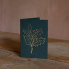 Holly Christmas card with gold line drawing on green cardstock, ideal for holiday greetings and festive wishes.